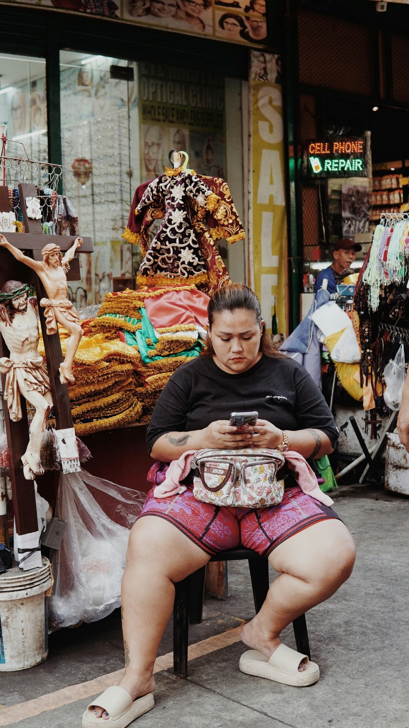 Vendeur consultant son téléphone dans un marché